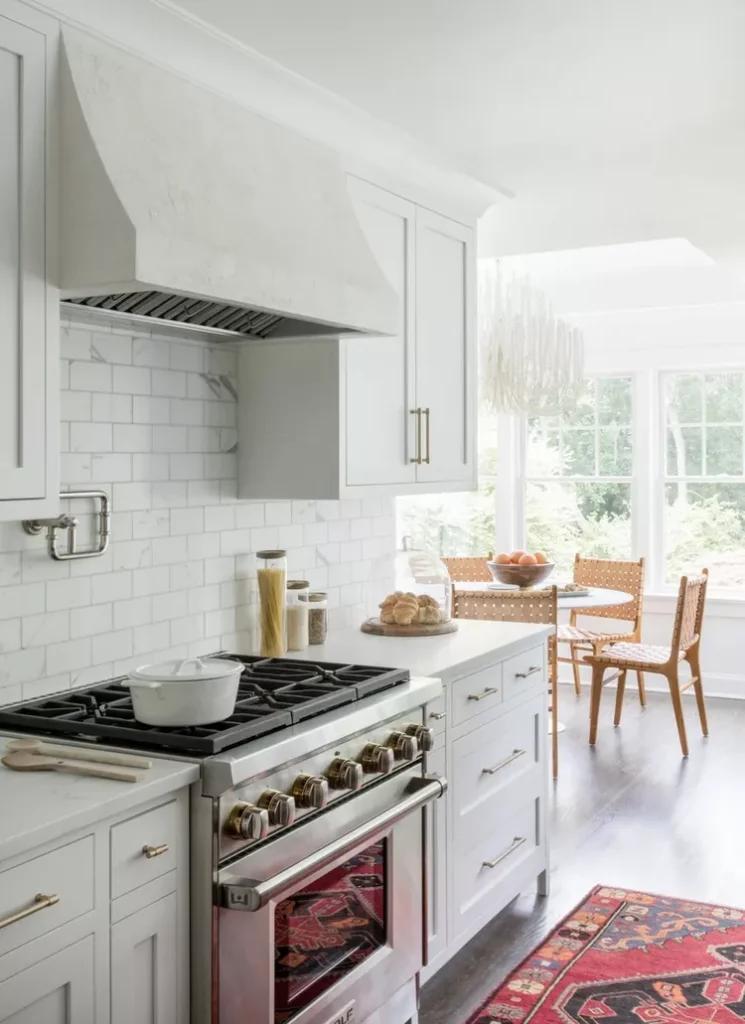 Cocina blanca y dorada con azulejos tipo metro